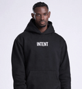 Person wearing a black hoodie with 'INTENT' text on a white background