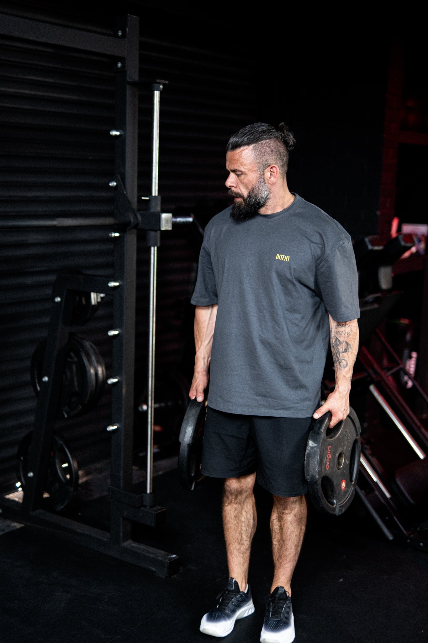 Man holding weight plates in a gym setting