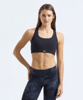 Woman wearing a black sports bra and leggings on a white background