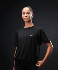 Person wearing a black outfit against a dark background