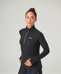 Woman wearing a black long-sleeve top with a zipper on a gray background