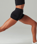 Person wearing black athletic shorts on a gray background